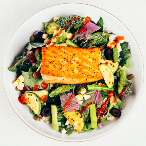 Seared salmon fillet salad bowl with grilled zucchini and asparagus
