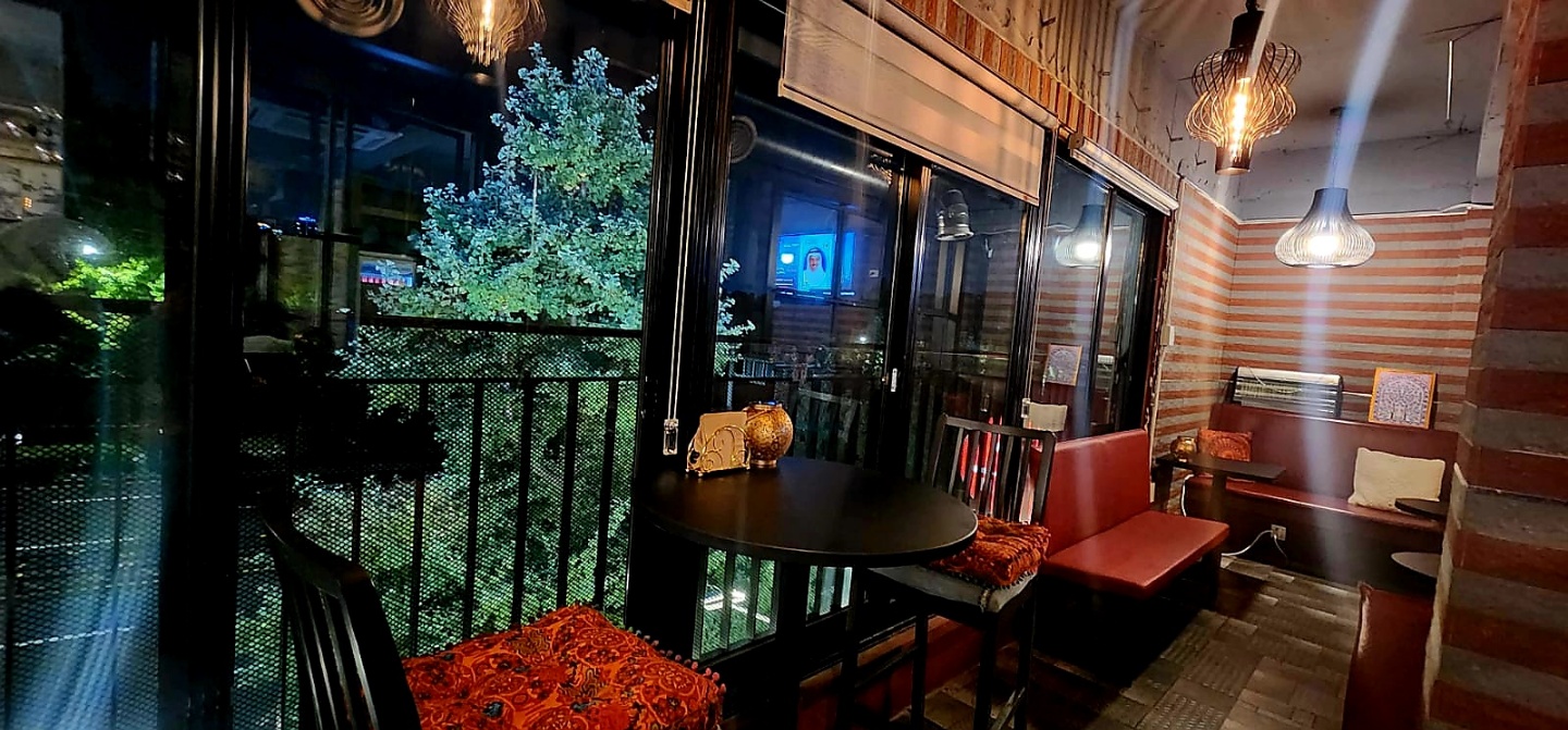 Evening dining room seating looking out through floor-to-ceiling windows