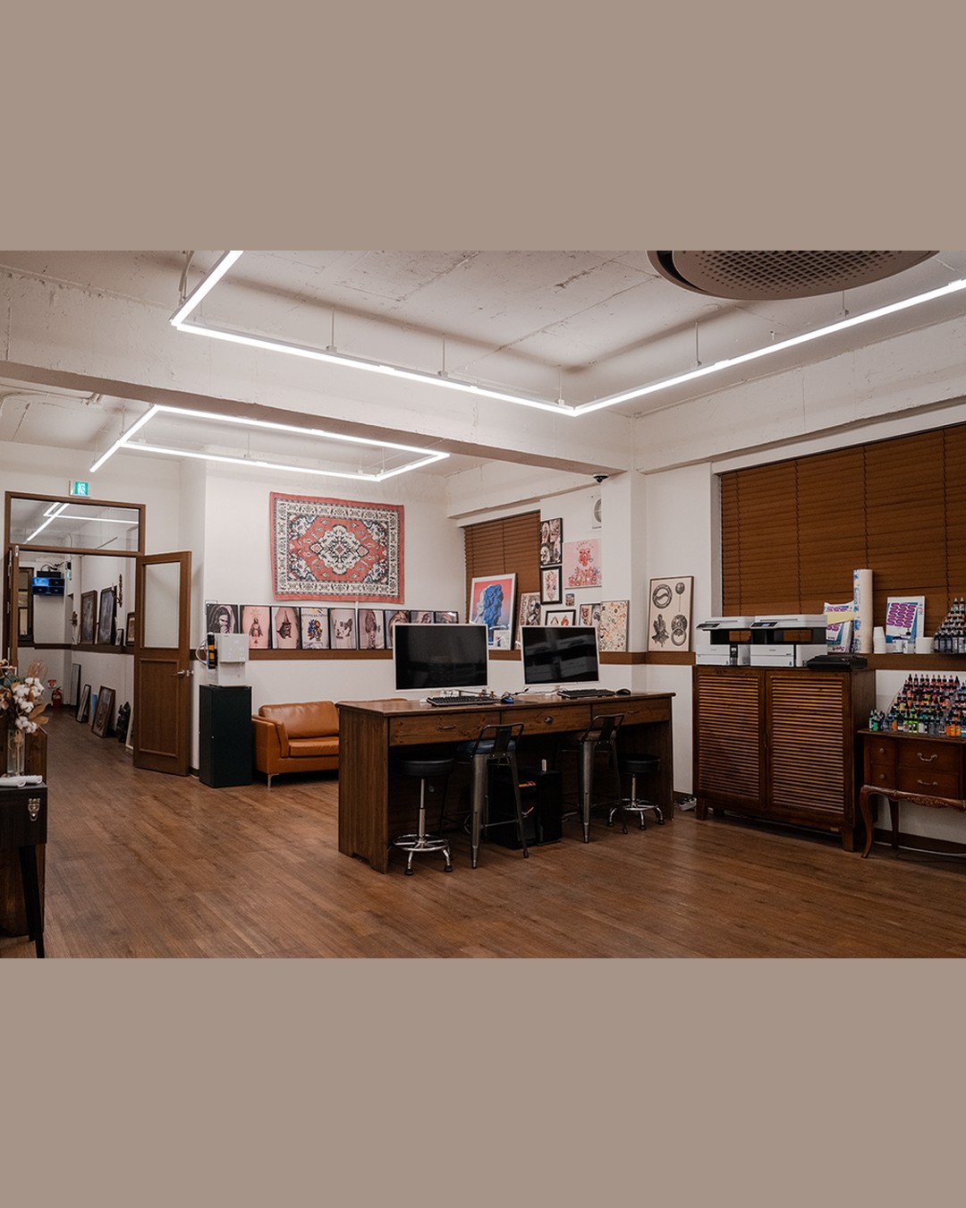 Studio workstation featuring digital design displays and art collection at Ape Ink Studio