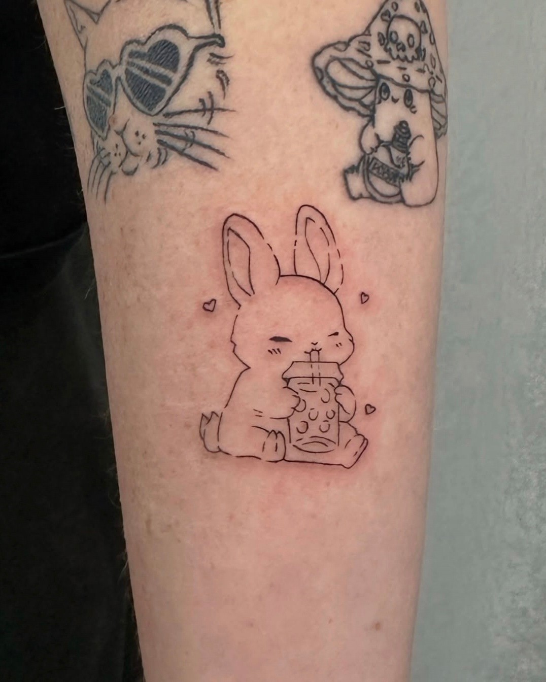 Fine-line illustrative style rabbit tattoo on forearm