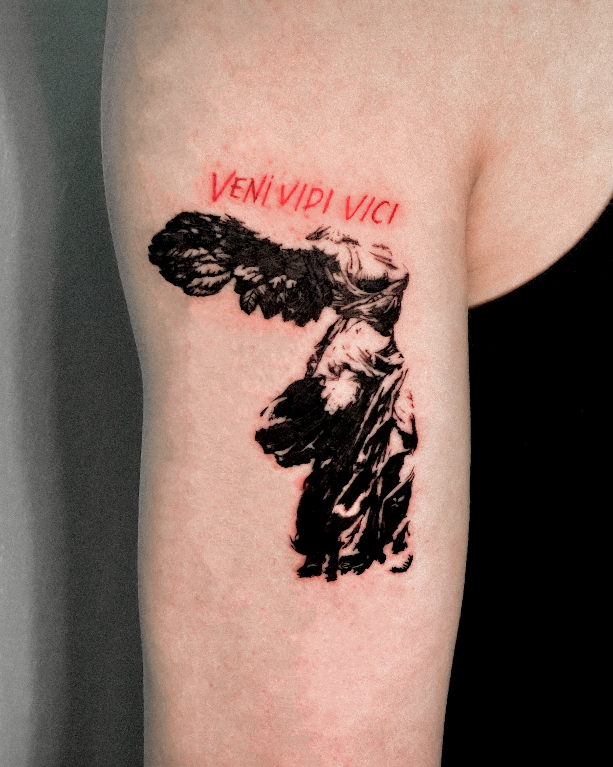 Winged Victory sculpture tattoo with red ink Latin lettering