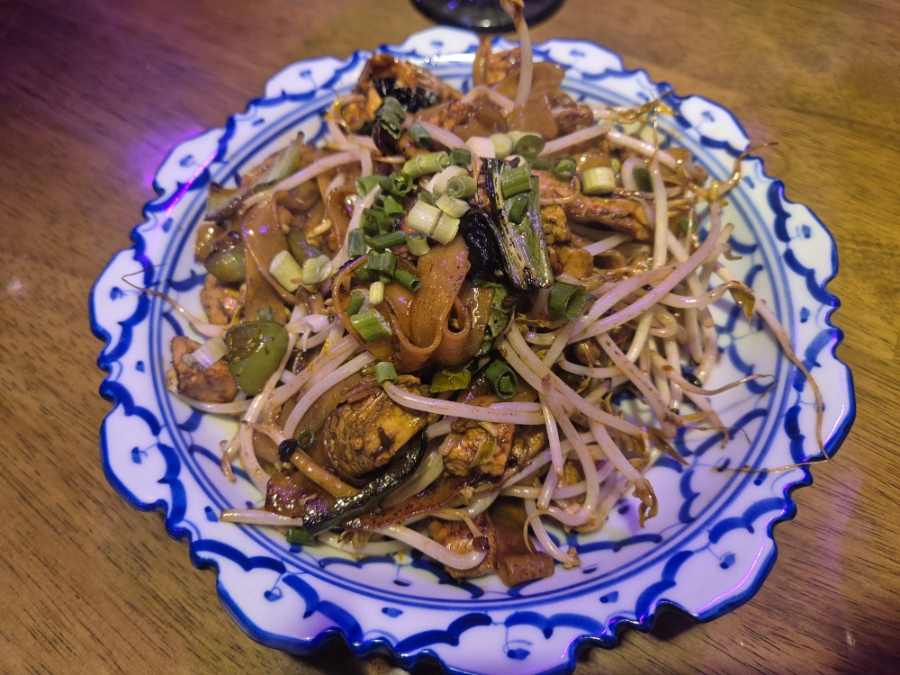 Stir-fried noodles with bean sprouts served on blue patterned plate