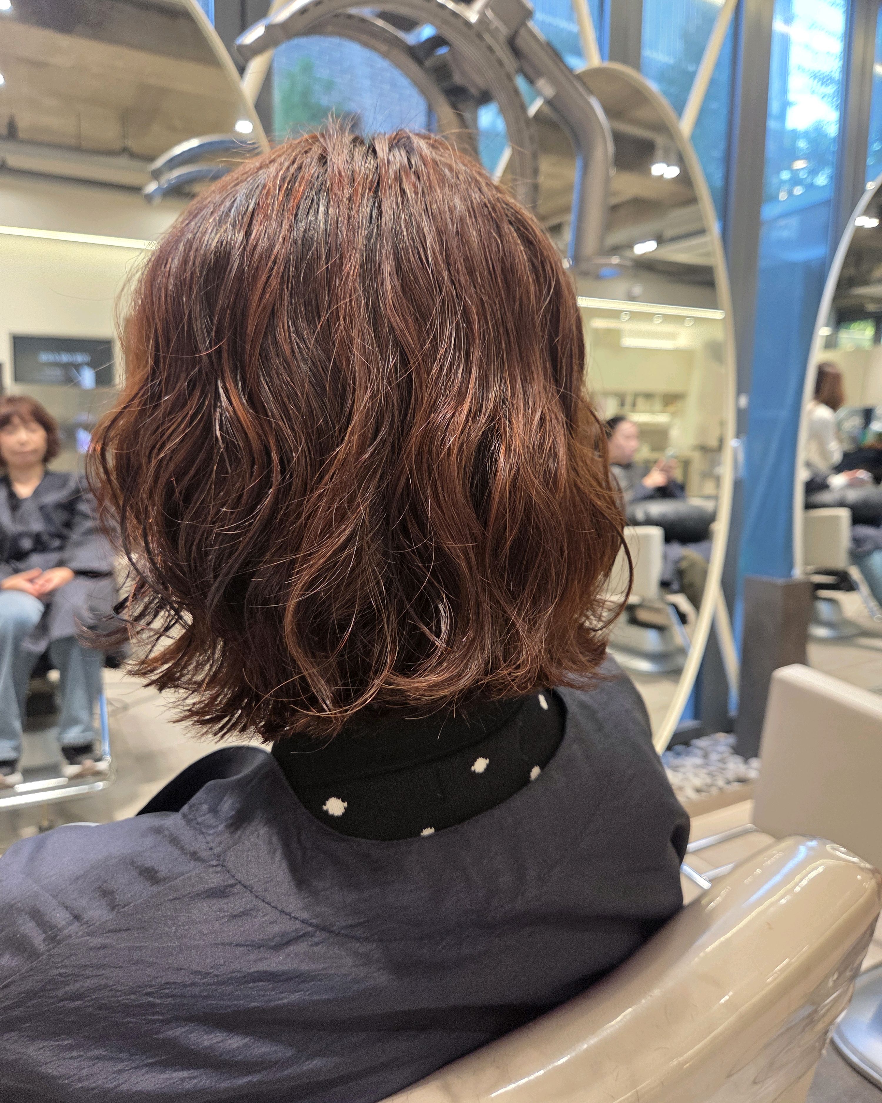 Wavy reddish-brown hair color treatment viewed from behind