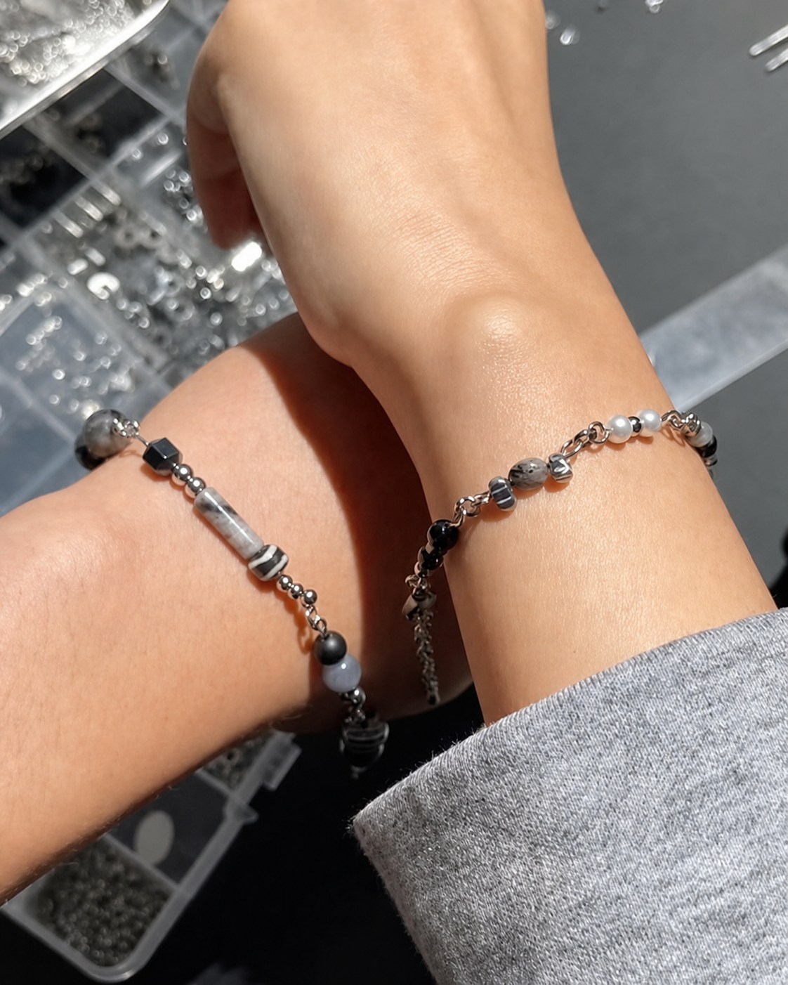 Two handmade bracelets worn over the workshop materials tray