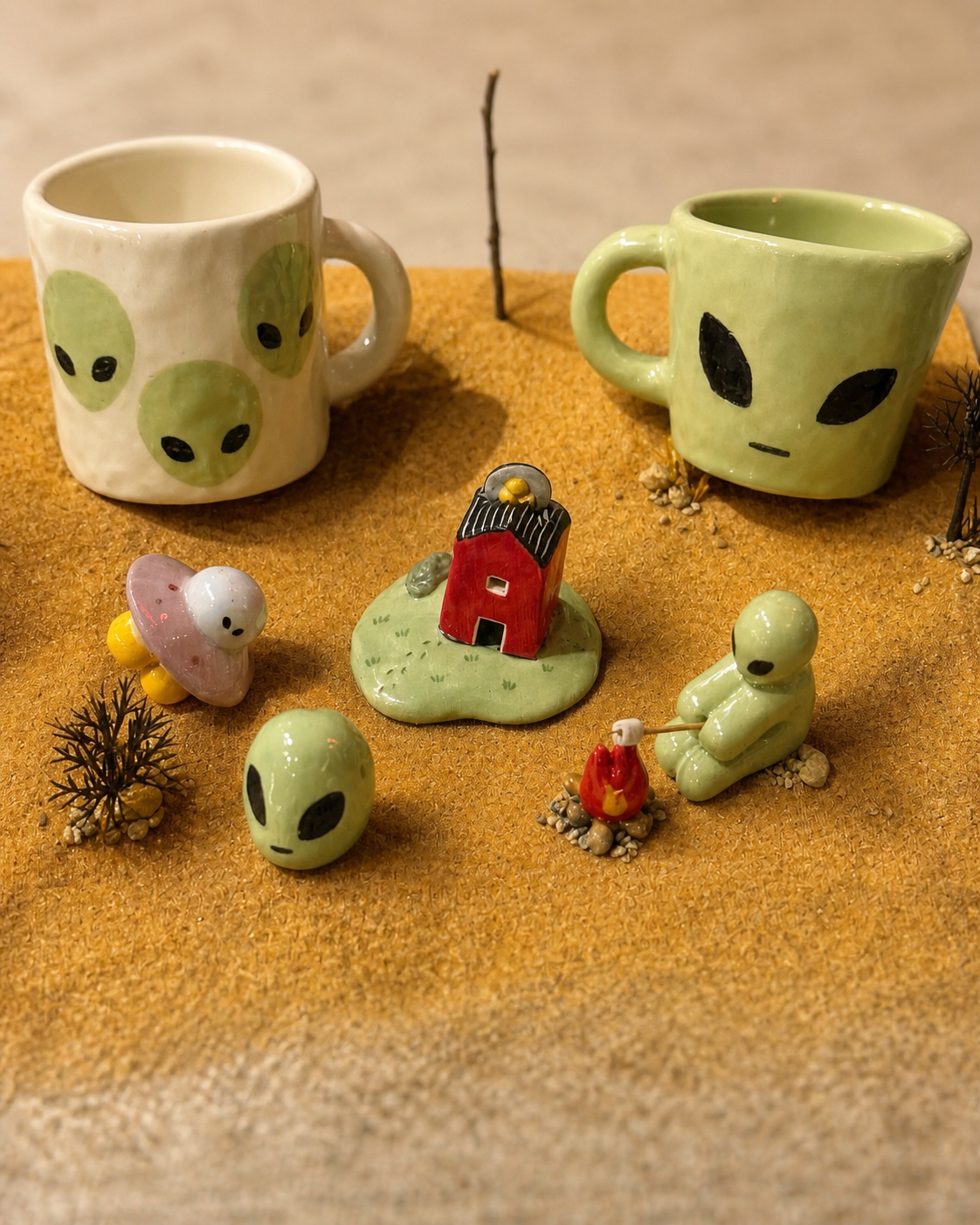 Art-directed catalog photograph of alien-themed ceramic mugs and miniature figurines at Yeoul