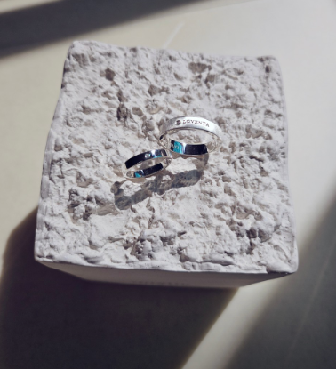 Loventa silver rings on a textured stone display